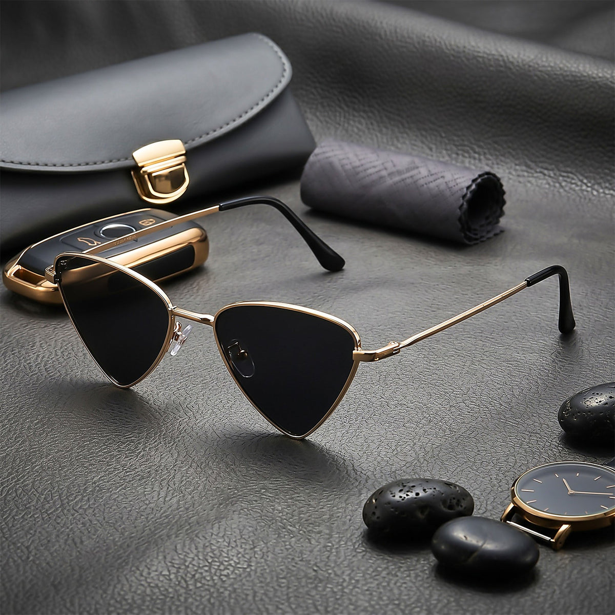ROSHFORT gold triangular sunglasses on leather with a watch and river stones