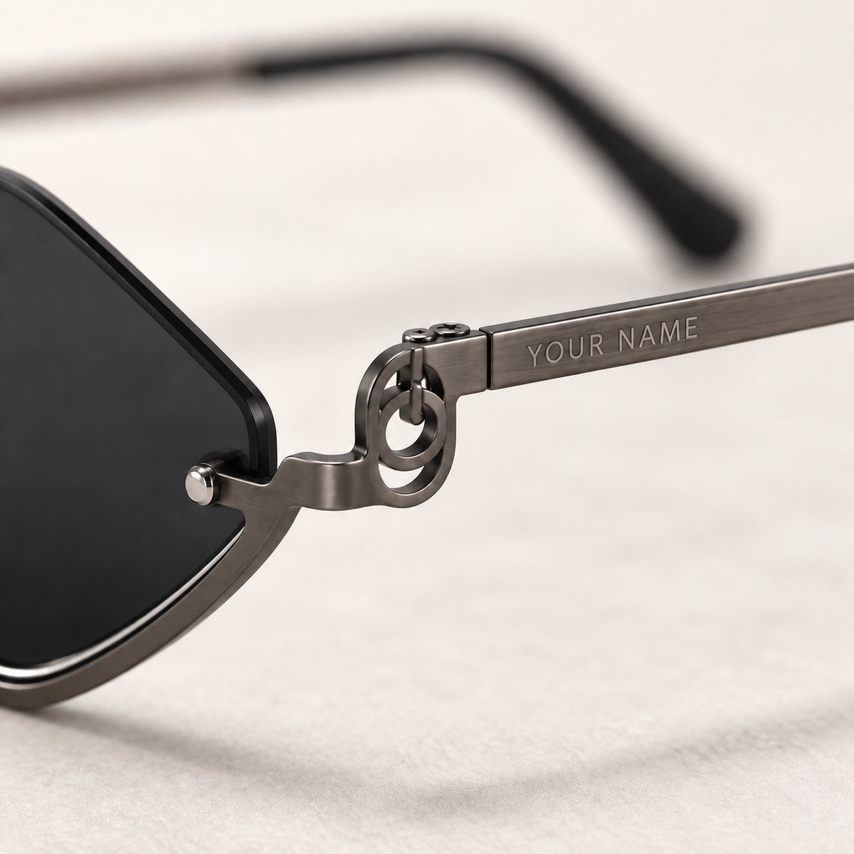 Close-up of your name laser engraved on the temple of the Noir Facet sunglasses