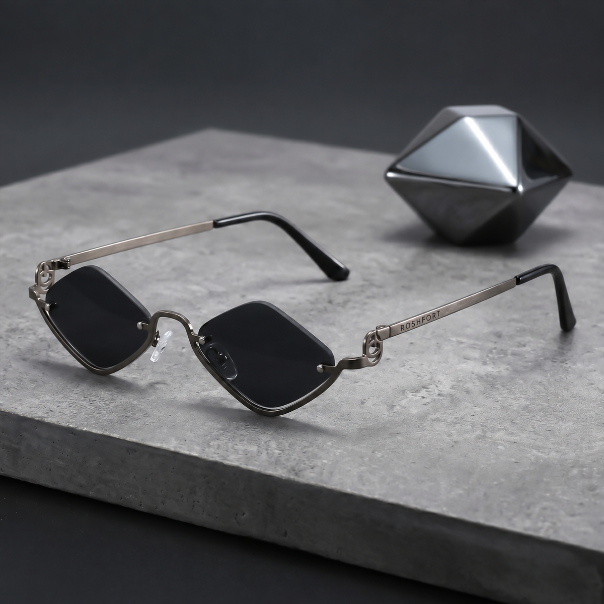 ROSHFORT Noir Facet sunglasses on a stone slab, ROSHFORT engraved on the temple