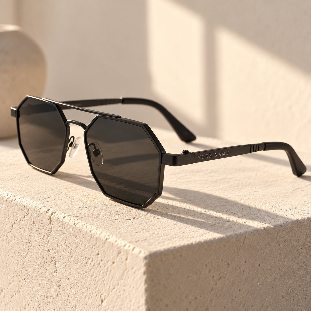 ROSHFORT Noir Hexa personalised sunglasses on a plaster pedestal, your name engraved on the temple