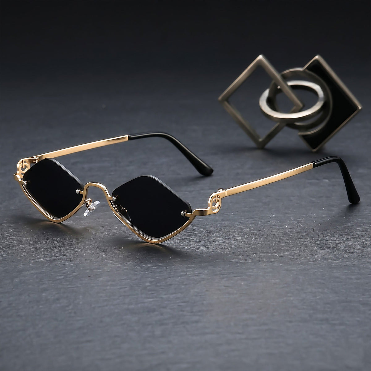 ROSHFORT gold faceted sunglasses on dark slate with brass objects