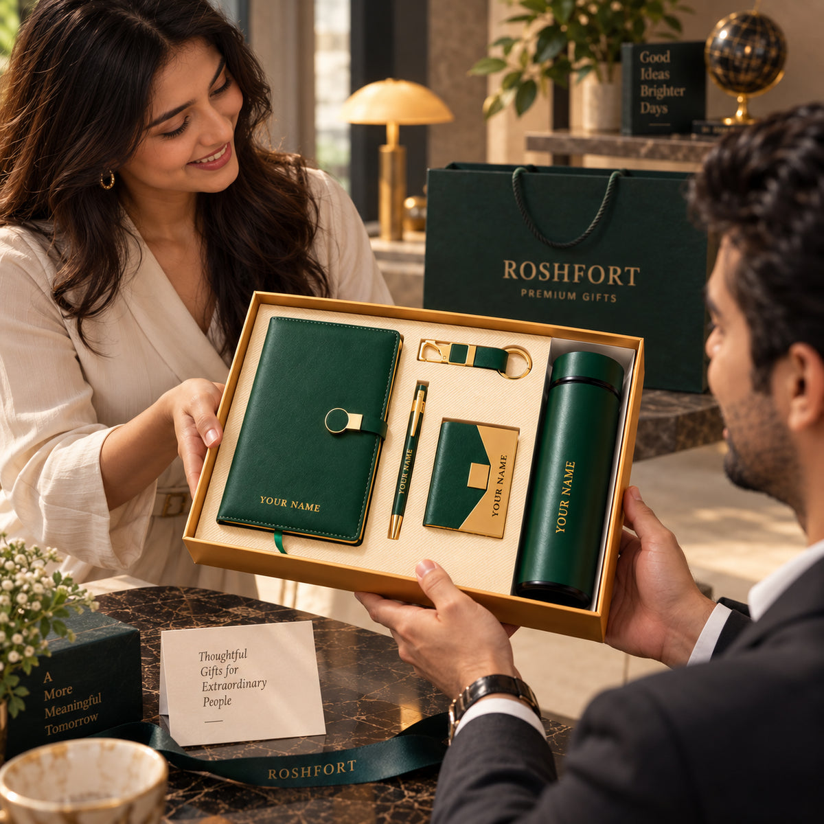 A woman and man hold an open green gift-set box with sample name lettering visible on several pieces.