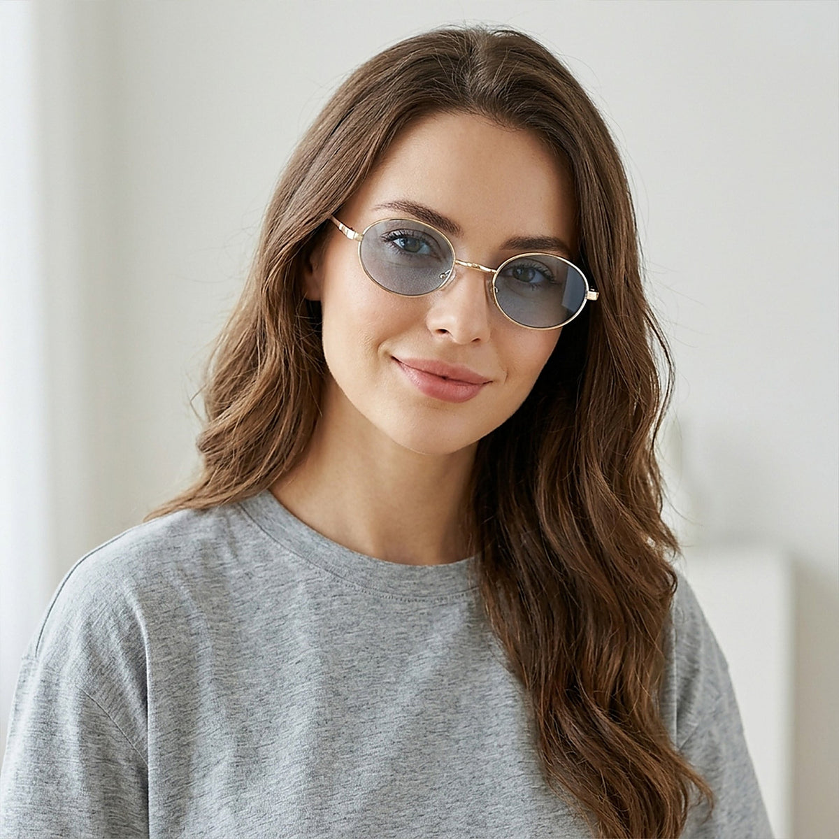 Woman wearing ROSHFORT gold oval sunglasses with light blue lenses