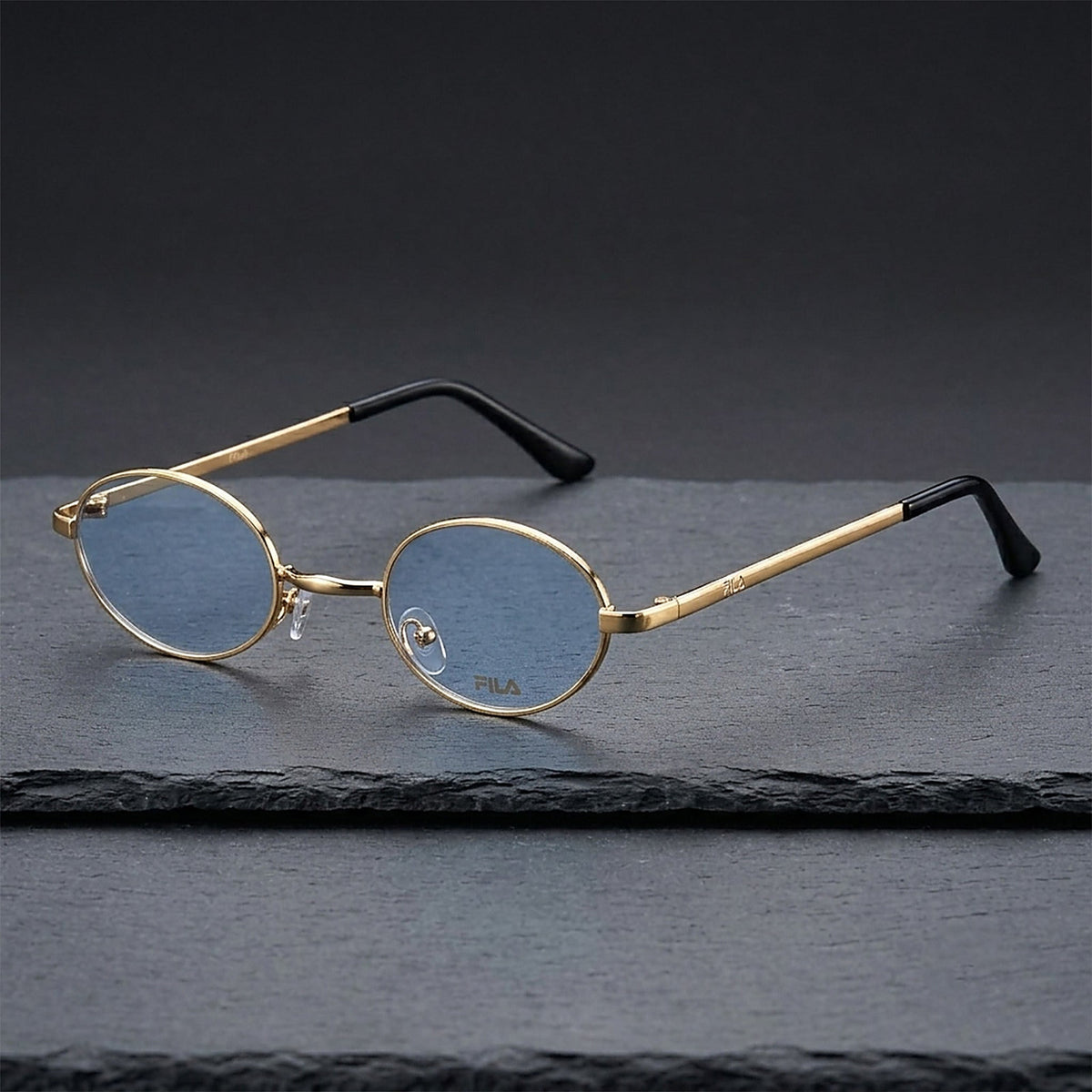 ROSHFORT gold oval blue-lens sunglasses resting on dark slate