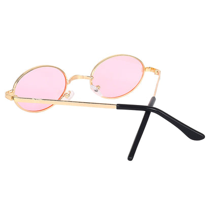 Gold oval sunglasses at an angle showing the pink lenses