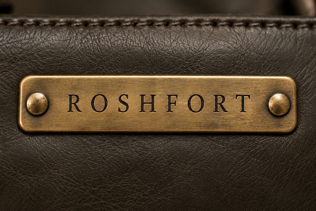 Close-up of the aged brass ROSHFORT name plate on the black leather