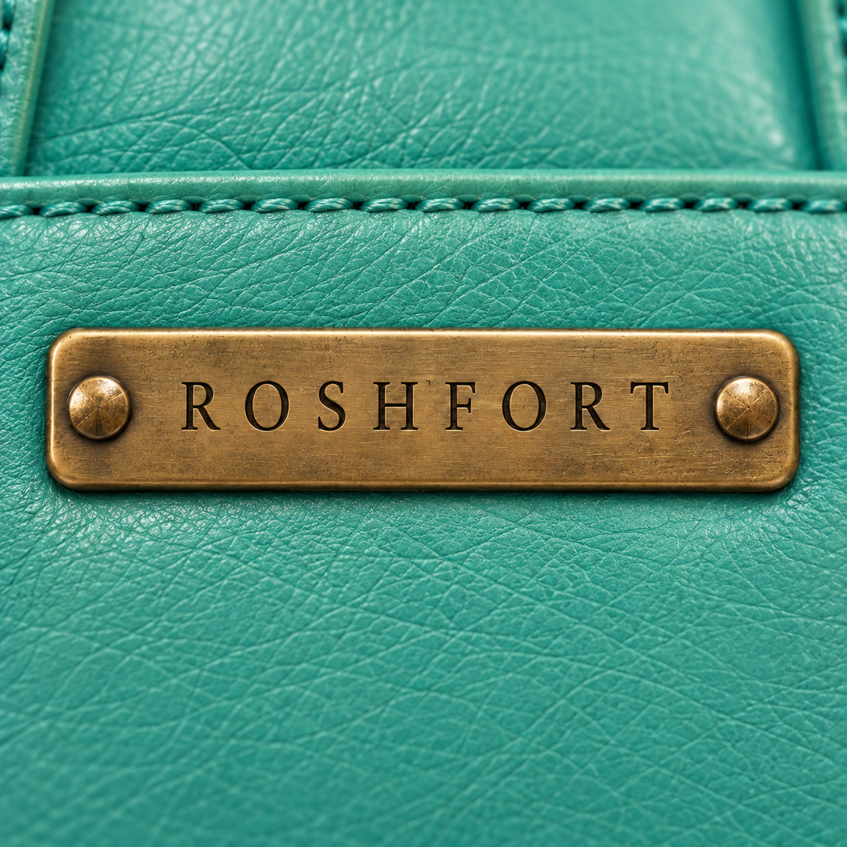 Close-up of the brass plate on the teal Albert briefcase - this is where your name is engraved