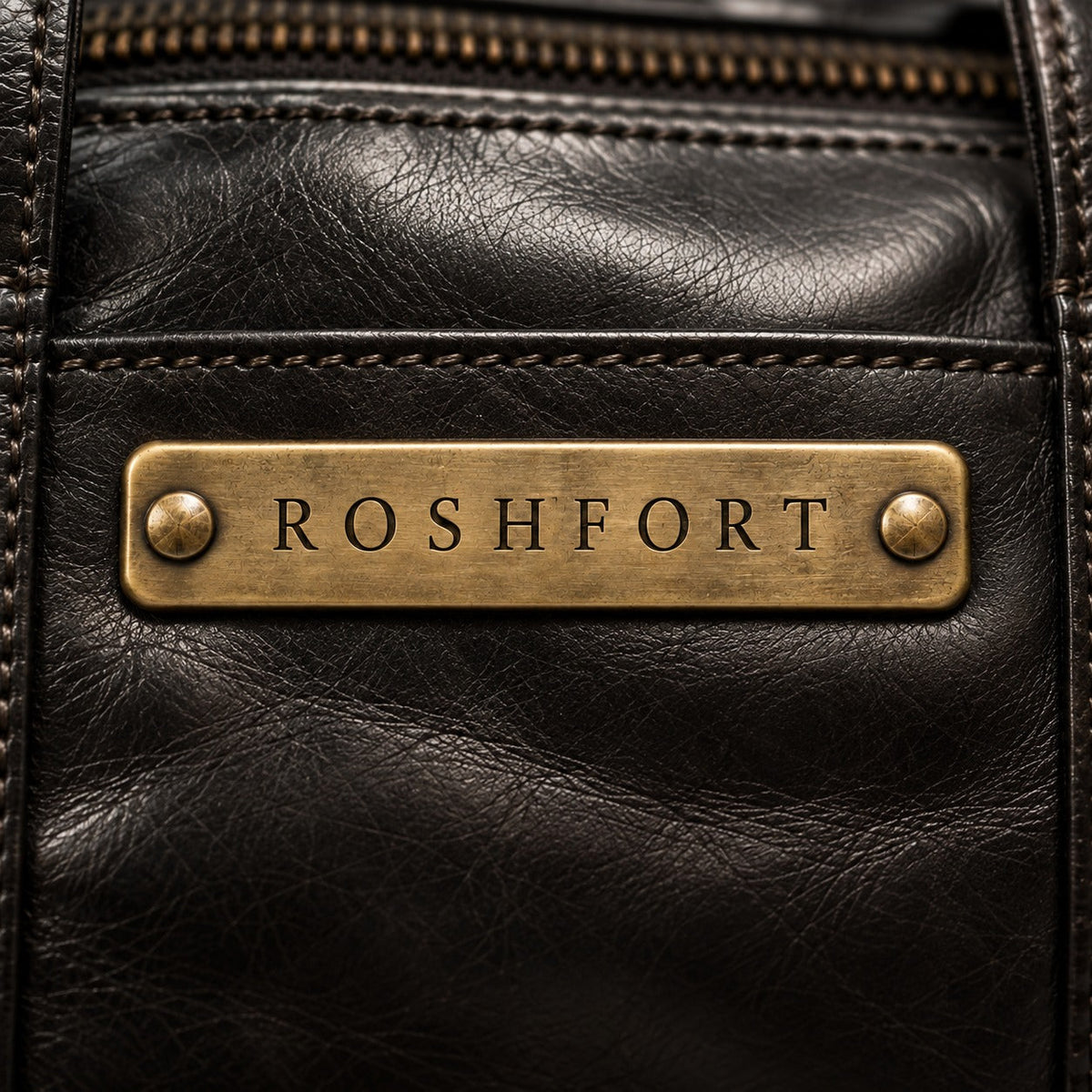 Close-up of the aged brass ROSHFORT name plate riveted to the black crunch leather