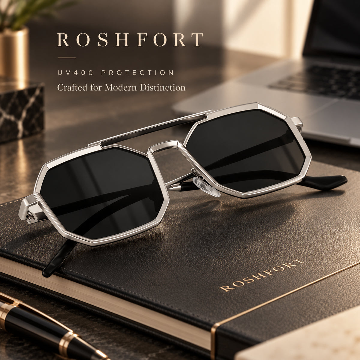 Silver octagonal sunglasses with dark lenses and a double bridge resting on a dark notebook.